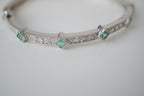 Silver tone bangle bracelet with white and green stones