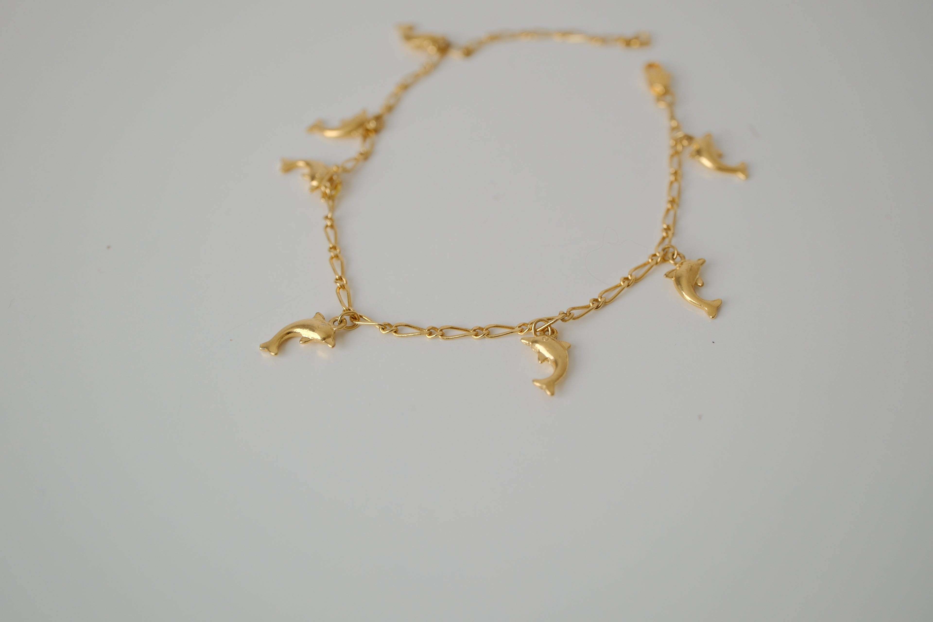 Gold tone dolphin charm bracelet