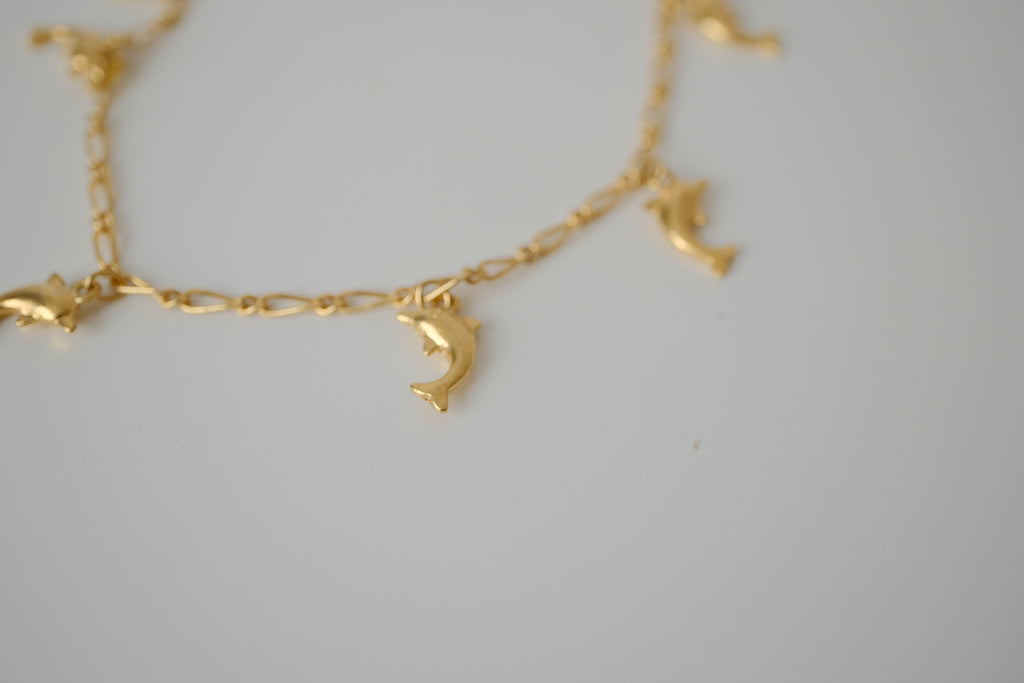 Gold tone dolphin charm bracelet