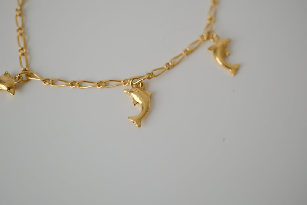 Gold tone dolphin charm bracelet