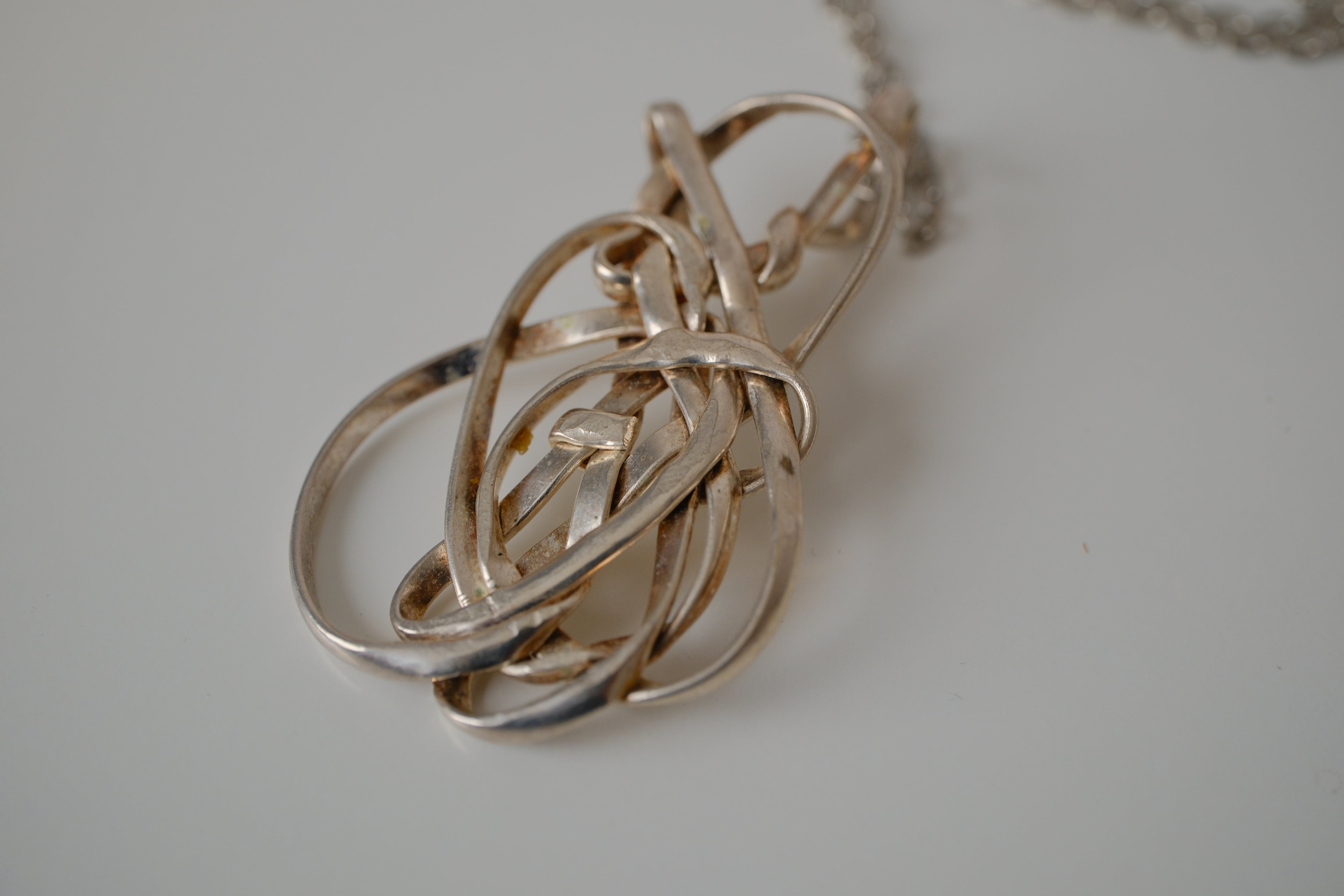 Modern intewined silver tone pendant necklace