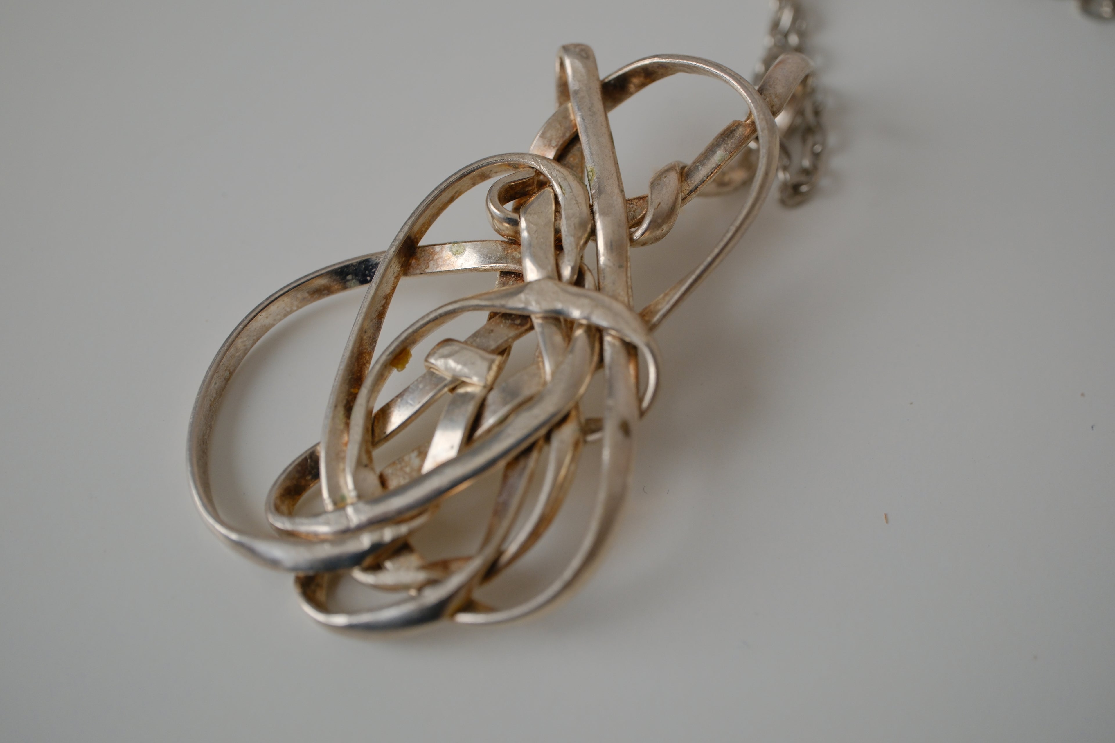 Modern intewined silver tone pendant necklace