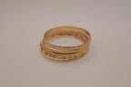 Set of 5 textured and engraved gold tone stacking bangle bracelets