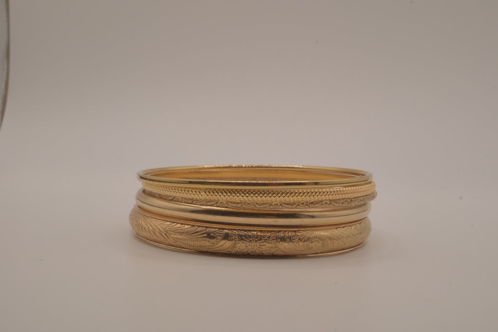 Set of 5 stacked gold bangle bracelets with intricate details