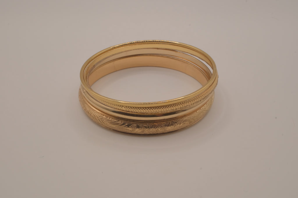 Set of 5 stacked gold bangle bracelets with intricate details