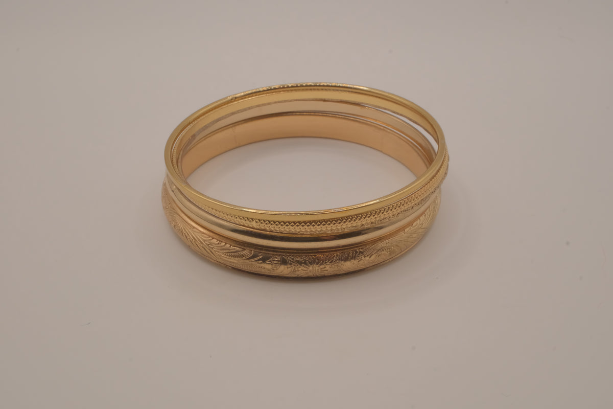 Set of 5 stacked gold bangle bracelets with intricate details