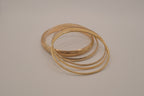 Set of 5 stacked gold bangle bracelets with intricate details