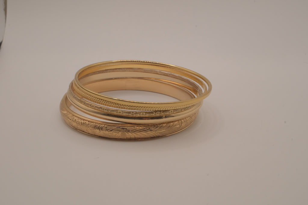 Set of 5 stacked gold bangle bracelets with intricate details