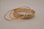 Set of 5 stacked gold bangle bracelets with intricate details
